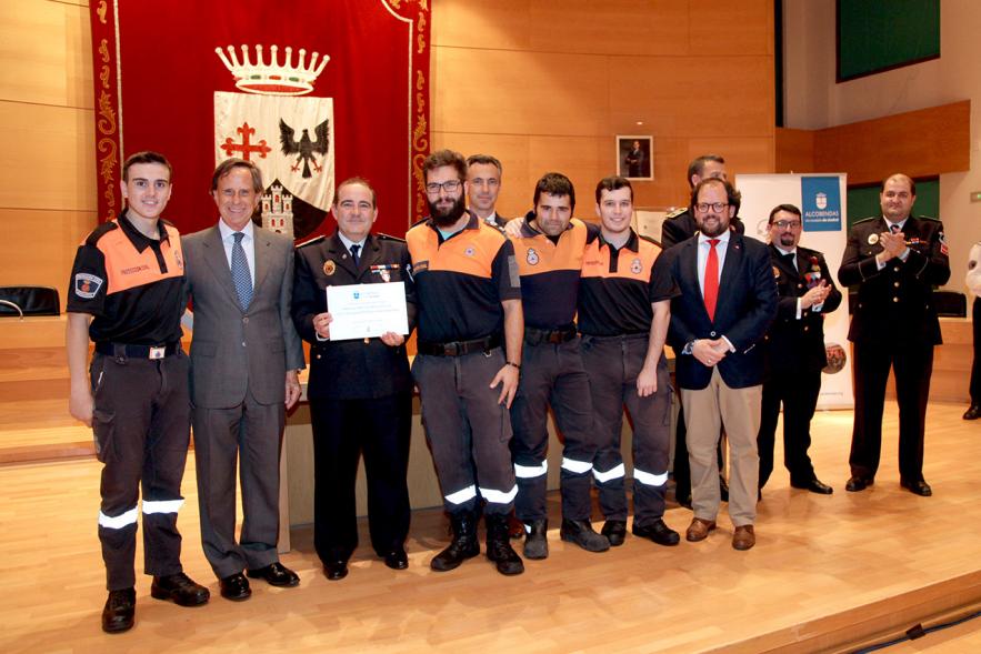 Entrega de Medallas de Protección Civil 2018 - Imagen de un miembro de Protección Civil posando con su medalla y su diploma posando junta a las autoridades que se lo han entregado, entre ellas el alcalde García de Vinuesa.