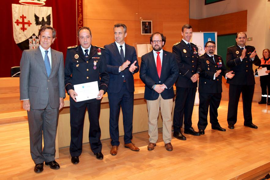 Entrega de Medallas de Protección Civil 2018 - Imagen de un miembro de Protección Civil posando con su medalla y su diploma posando junta a las autoridades que se lo han entregado, entre ellas el alcalde García de Vinuesa.