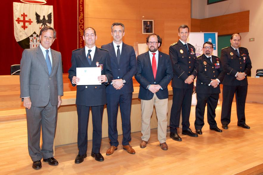 Entrega de Medallas de Protección Civil 2018 -  Imagen de una persona posando con su medalla y su diploma posando junta a las autoridades que se lo han entregado, entre ellas el alcalde García de Vinuesa.