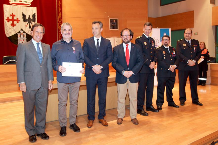 Entrega de Medallas de Protección Civil 2018 -  Imagen de una persona posando con su medalla y su diploma posando junta a las autoridades que se lo han entregado, entre ellas el alcalde García de Vinuesa.