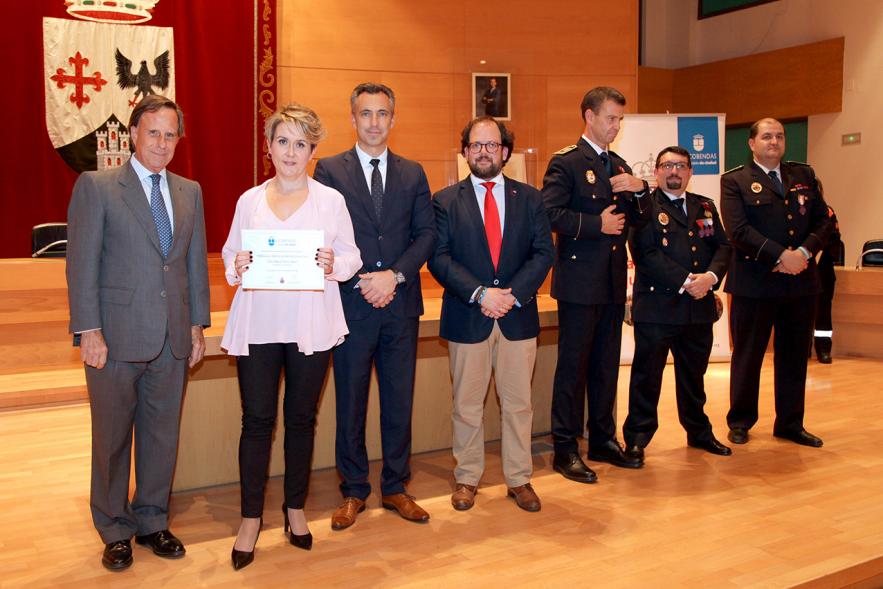 Entrega de Medallas de Protección Civil 2018 - Imagen de una mujer posando con su medalla y su diploma posando junta a las autoridades que se lo han entregado, entre ellas el alcalde García de Vinuesa.