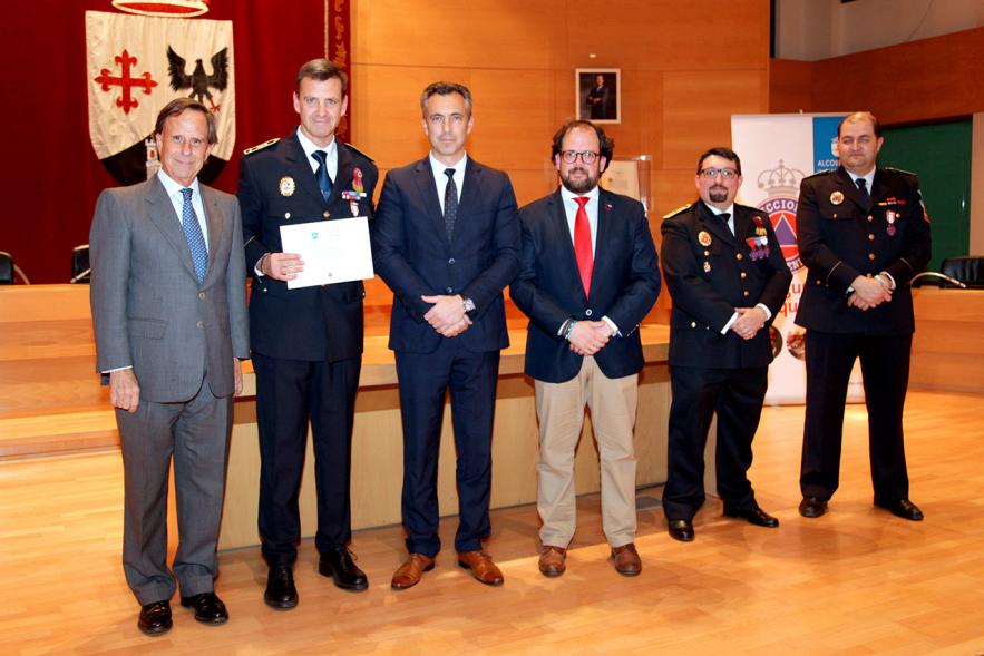 Entrega de Medallas de Protección Civil 2018 - Imagen de una persona posando con su medalla y su diploma posando junta a las autoridades que se lo han entregado, entre ellas el alcalde García de Vinuesa.