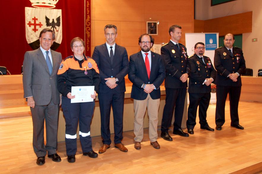 Entrega de Medallas de Protección Civil 2018 - Imagen de una miembra de Protección Civil.  posando con su medalla y su diploma posando junta a las autoridades que se lo han entregado, entre ellas el alcalde García de Vinuesa.