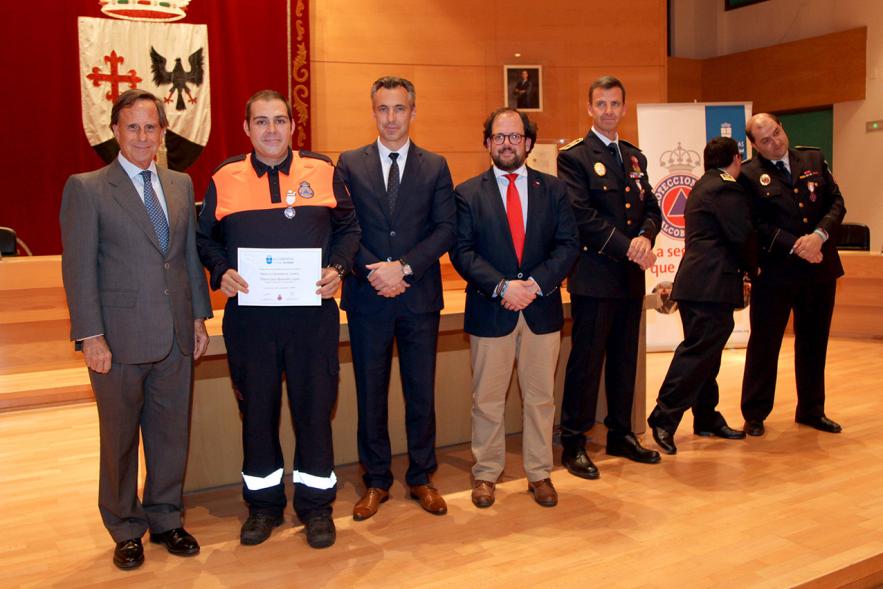 Entrega de Medallas de Protección Civil 2018 - Imagen de un miembro de Protección Civil posando con su medalla y su diploma posando junta a las autoridades que se lo han entregado, entre ellas el alcalde García de Vinuesa.