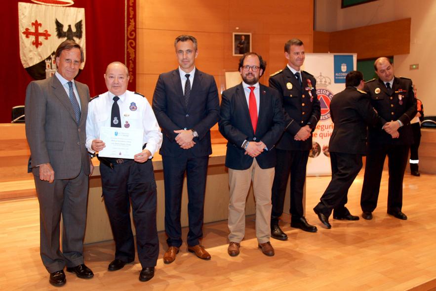 Entrega de Medallas de Protección Civil 2018 - Imagen de un miembro de Protección Civil posando con su medalla y su diploma posando junta a las autoridades que se lo han entregado, entre ellas el alcalde García de Vinuesa.