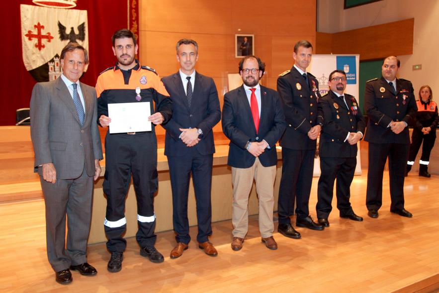 Entrega de Medallas de Protección Civil 2018 - Imagen de un miembro de Protección Civil posando con su medalla y su diploma posando junta a las autoridades que se lo han entregado, entre ellas el alcalde García de Vinuesa.