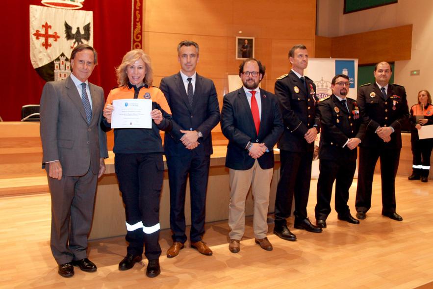 Entrega de Medallas de Protección Civil 2018 - Imagen de una miembra de Protección Civil posando con su medalla y su diploma posando junta a las autoridades que se lo han entregado, entre ellas el alcalde García de Vinuesa.