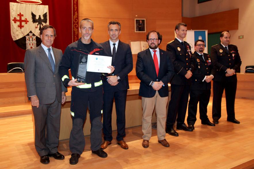 Entrega de Medallas de Protección Civil 2018 -  Imagen de una persona posando con su medalla y su diploma posando junta a las autoridades que se lo han entregado, entre ellas el alcalde García de Vinuesa.