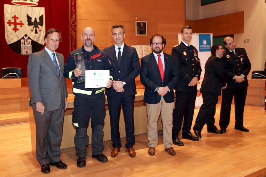 Entrega de Medallas de Protección Civil 2018 - Imagen de una persona posando con su medalla y su diploma posando junta a las autoridades que se lo han entregado, entre ellas el alcalde García de Vinuesa.