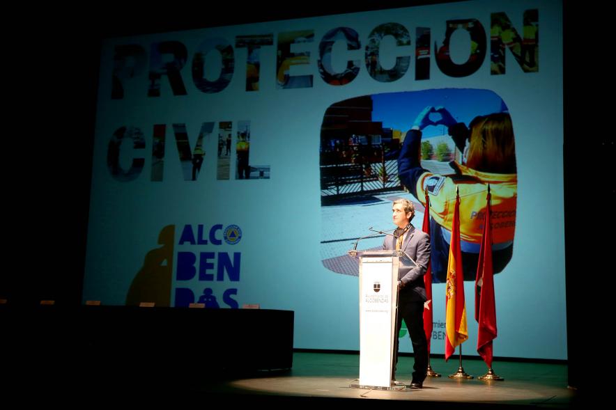 Entrega Reconocimientos de Protección Civil - Imagen del escenario con Aitor Retolaza de la corporación municipal junto al cartel proyectado del evento.