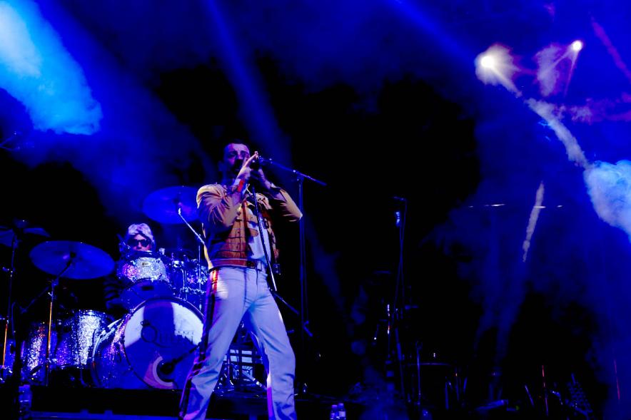 Cantante durante el concierto con la indumentaria de Freddie Mercury y el brazo alzado