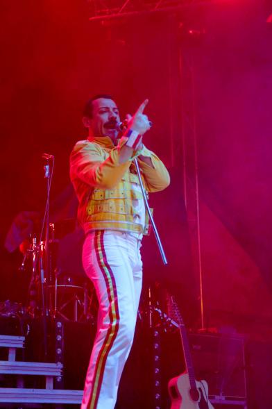 Cantante del grupo vestido e imitando a Freddie Mercury