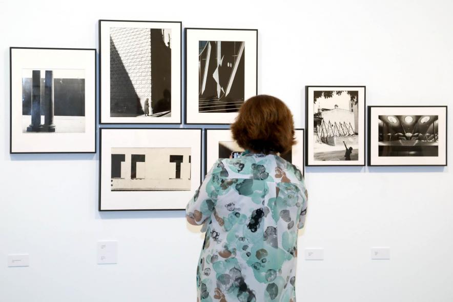 Inauguración Exposición Ramón Masats - Imagen de una mujer mirando una fotografía.