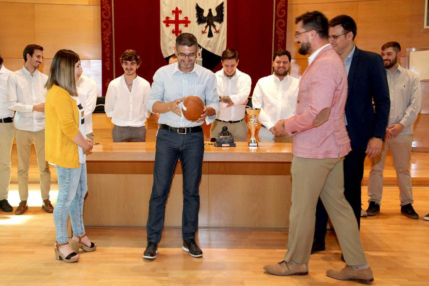 Recepción Equipo Fútbol Americano Royal Oaks Knights - Imagen de la entrega de un balón al alcalde Sánchez Acera por el representante del equipo junto al resto de la corporación municipal.