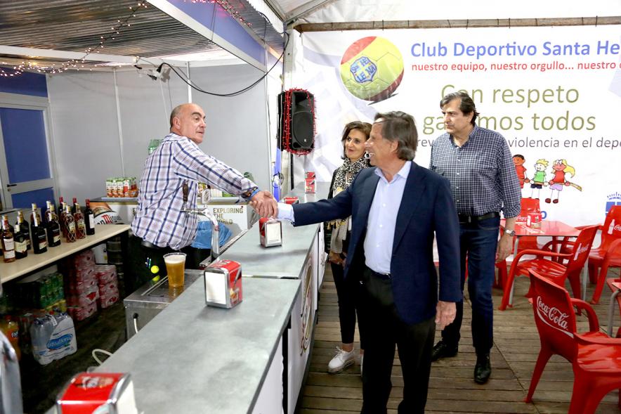Miembros del consistorio saludan a un voluntario en la caseta del CD Santa Helena