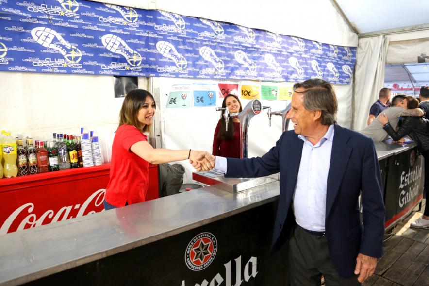 Alcalde García de Vinuesa dando la mano a voluntaria en la caseta del Club De Corredores
