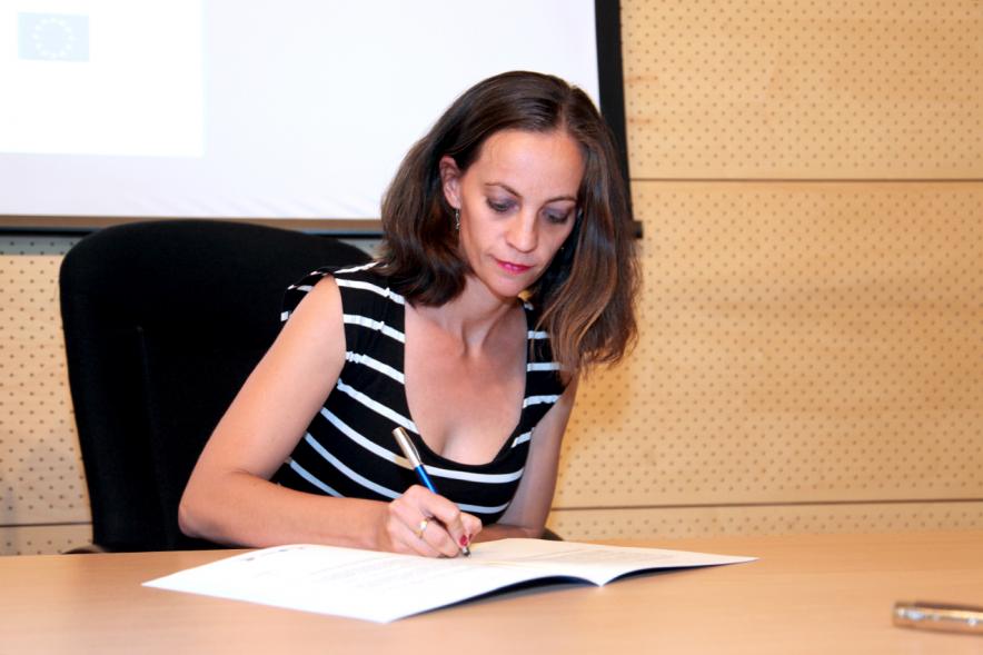 Entrega Reconocimiento Empresas por Igualdad Salarial y Alcobendas Concilia - Persona asistente al acto firmando unos documentos.