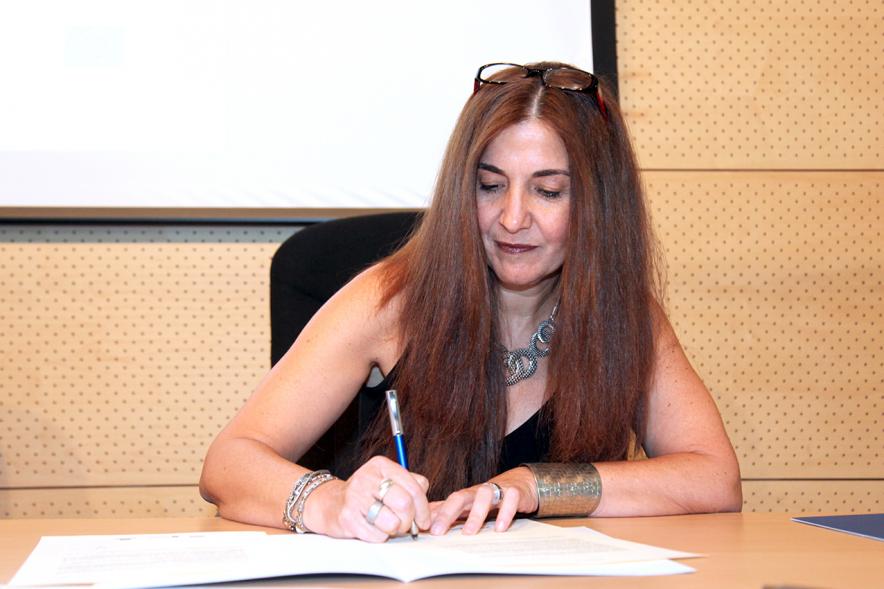 Entrega Reconocimiento Empresas por Igualdad Salarial y Alcobendas Concilia - Persona asistente al acto firmando unos documentos.