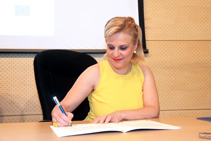 Entrega Reconocimiento Empresas por Igualdad Salarial y Alcobendas Concilia - Persona asistente al acto firmando unos documentos.