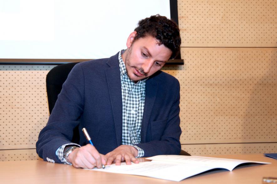 Entrega Reconocimiento Empresas por Igualdad Salarial y Alcobendas Concilia - Persona asistente al acto firmando unos documentos.