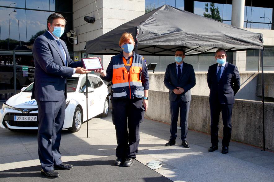 Entrega Reconocimiento a Toyota por Protección Civil de Madrid - Imagen de Miguel Carsi, CEO de Toyota, con mascarilla, entregando una placa a una voluntaria de Protección Civil. 