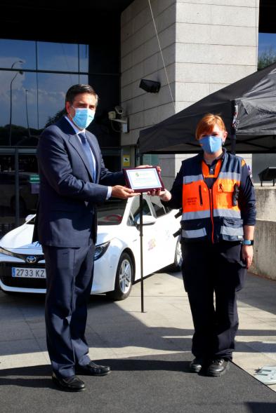 Entrega Reconocimiento a Toyota por Protección Civil de Madrid - Imagen de Miguel Carsi, CEO de Toyota, con mascarilla, entregando una placa a una voluntaria de Protección Civil. 