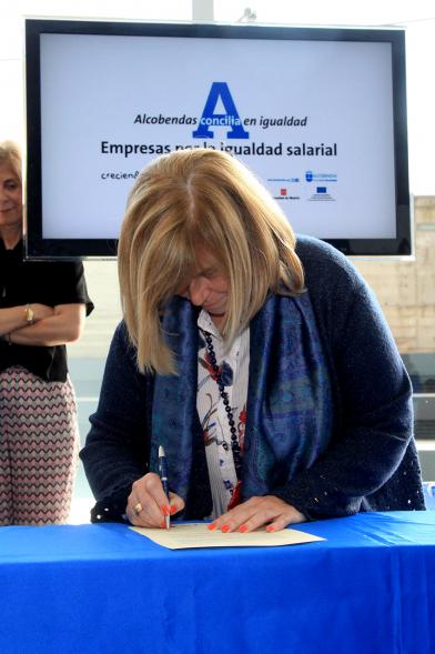 Reconocimiento a Empresas por Igualdad Salarial y Alcobendas Concilia - Persona asistente al acto firmando unos documentos.