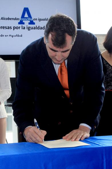 Reconocimiento a Empresas por Igualdad Salarial y Alcobendas Concilia - Persona asistente al acto firmando unos documentos.
