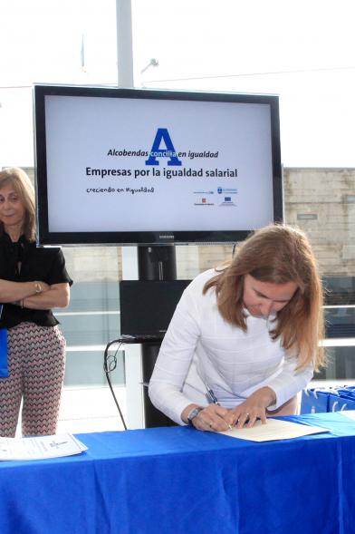 Reconocimiento a Empresas por Igualdad Salarial y Alcobendas Concilia - Persona asistente al acto firmando unos documentos.