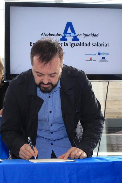 Reconocimiento a Empresas por Igualdad Salarial y Alcobendas Concilia - Persona asistente al acto firmando unos documentos.