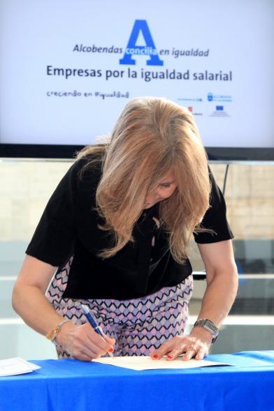Reconocimiento a Empresas por Igualdad Salarial y Alcobendas Concilia - Persona asistente al acto firmando unos documentos.