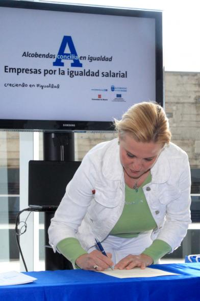 Reconocimiento a Empresas por Igualdad Salarial y Alcobendas Concilia - Persona asistente al acto firmando unos documentos.