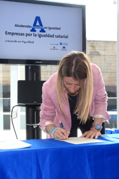 Reconocimiento a Empresas por Igualdad Salarial y Alcobendas Concilia - Persona asistente al acto firmando unos documentos.
