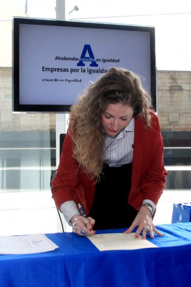Reconocimiento a Empresas por Igualdad Salarial y Alcobendas Concilia - Persona asistente al acto firmando unos documentos.
