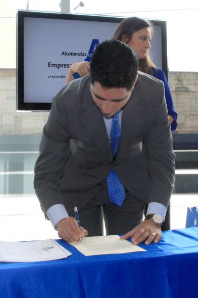Reconocimiento a Empresas por Igualdad Salarial y Alcobendas Concilia - Persona asistente al acto firmando unos documentos.