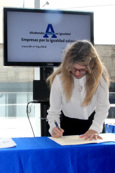 Reconocimiento a Empresas por Igualdad Salarial y Alcobendas Concilia - Persona asistente al acto firmando unos documentos.