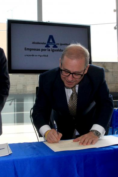Reconocimiento a Empresas por Igualdad Salarial y Alcobendas Concilia - Persona asistente al acto firmando unos documentos.