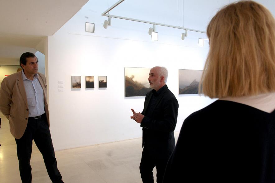 Inauguración Exposición "Requiem" en el C.C. Anabel Segura - Imagen del autor de la exposición Jesús Manse charlando con personas asistentes a la inauguración.
