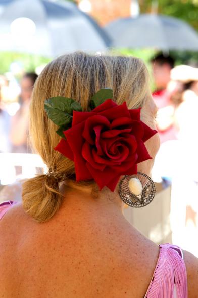 Detalle de mujer con rosa prendida en el pelo