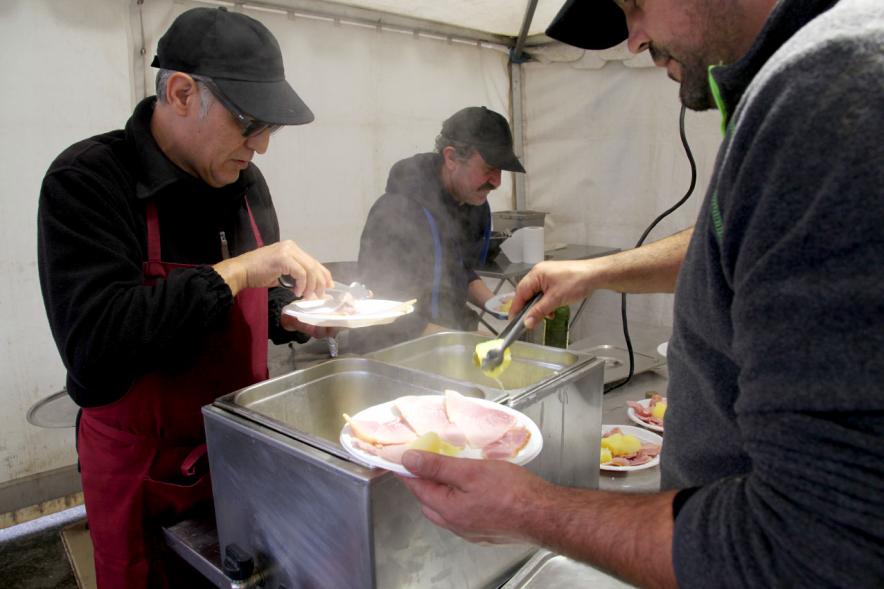 Semana Cultural Xuntanza de Galegos - Inauguración de la Romeria del Pulpo y el Mejillón - Imagen de alguien preparando comida.