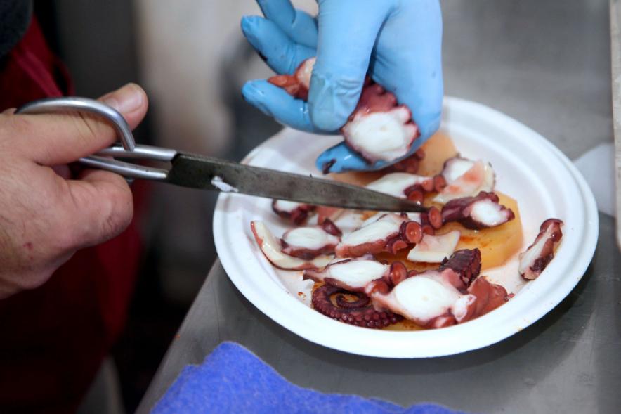 Semana Cultural Xuntanza de Galegos - Inauguración de la Romeria del Pulpo y el Mejillón - Imagen de persona cortando el pulpo.
