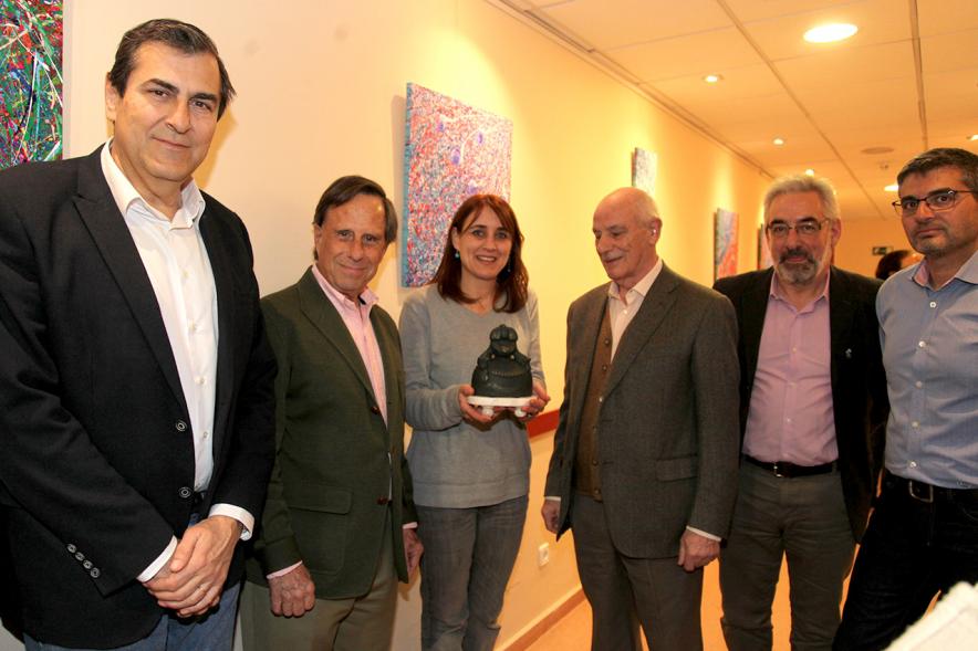 XXIIª Feria del Pulpo y el Mejillón - Imagen del alcalde García de Vinuesa visitando una exposición de cuadros acompañado de varias personas mientras la pintora de Marianela Fontoria les explica su obra.