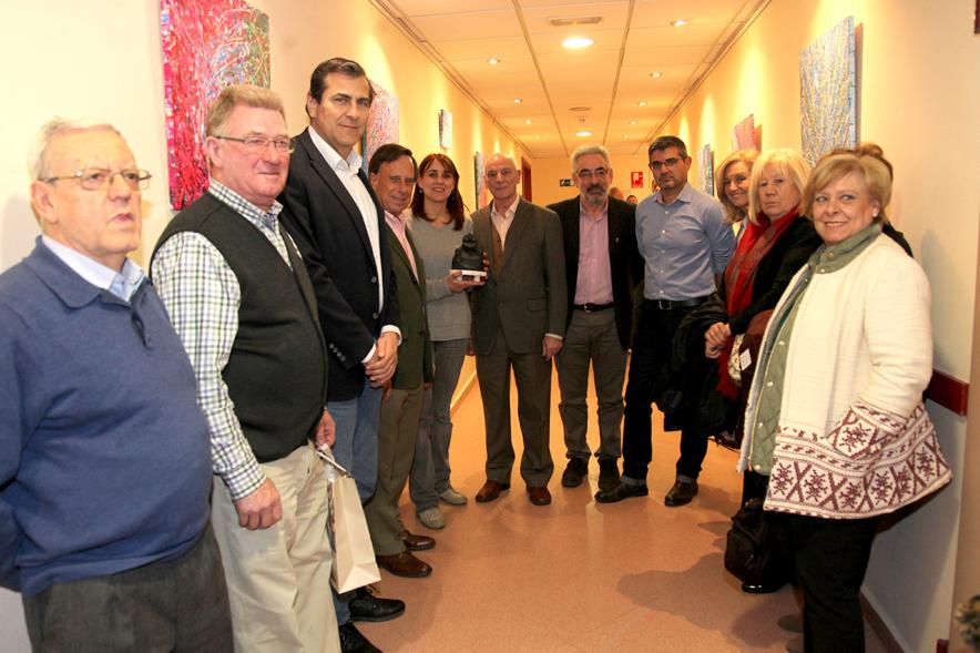 XXIIª Feria del Pulpo y el Mejillón - Imagen del alcalde García de Vinuesa visitando una exposición de cuadros acompañado de varias personas mientras la pintora de Marianela Fontoria les explica su obra.