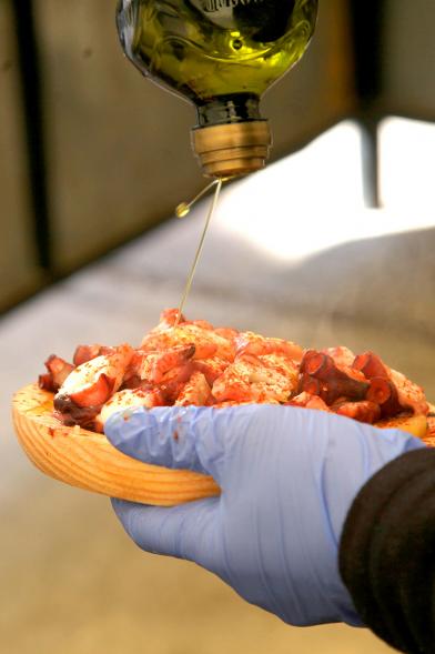 XXIIª Feria del Pulpo y el Mejillón - Imagen de un plato de "pulpo a feira" al que le añaden aceite de oliva.