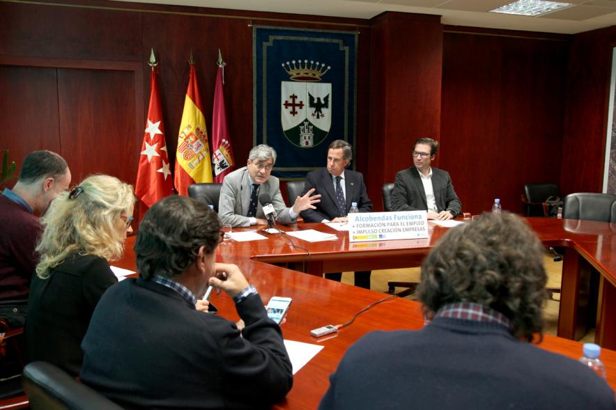 Rueda de Prensa Ayuntamiento - EOI - Imagen de una mesa redonda, persona dirigiéndos a los asistentes y entre ellos está el alcalde García de Vinuesa.