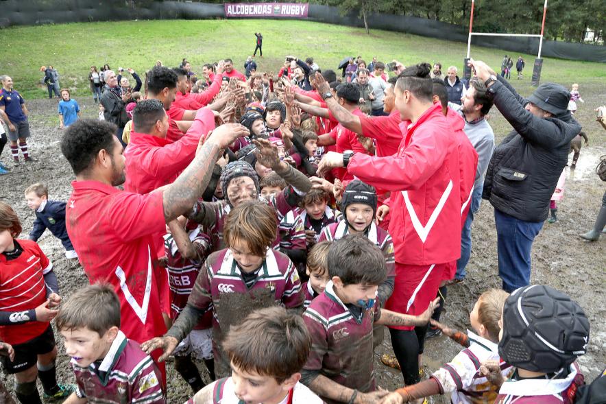 Encuentro de la Selección de Rugby de Tonga con las Escuelas de Rugby - Imagen de los niños de la escuela de rugby embarrados con miembros de la selección de Tonga.