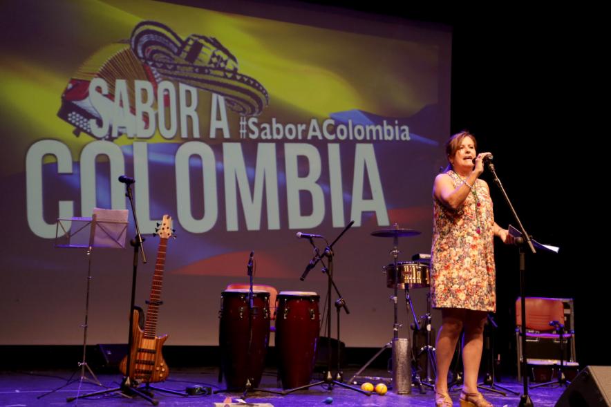 Acto Sabor a Colombia - Imagen de una persona en el escenario dirigiéndose al público asistente.