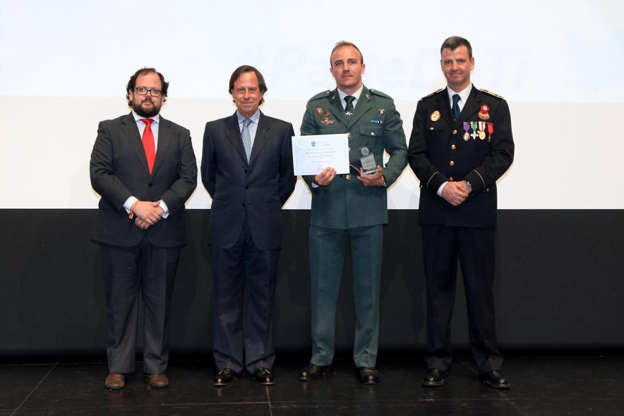 Festividad de San Juan de la Policía Local - El alcalde García de Vinuesa y otras autoridades en el escenario con un galardonado.
