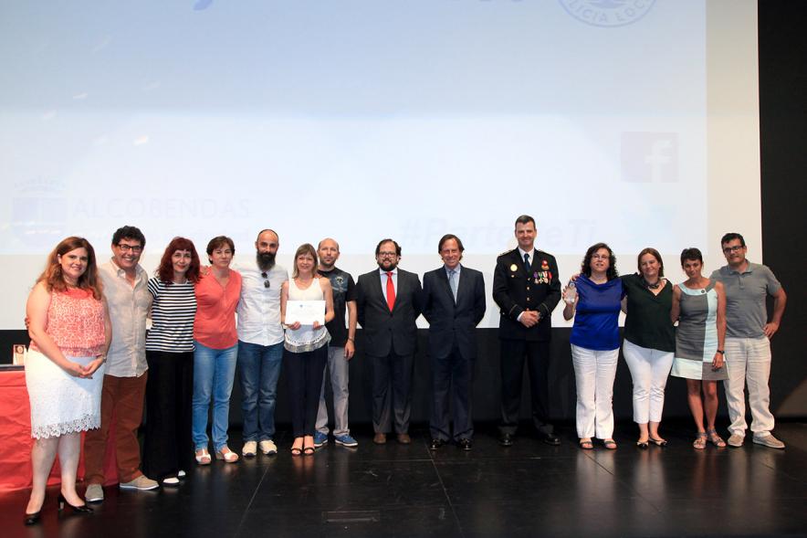 Festividad de San Juan de la Policía Local - El alcalde García de Vinuesa, otras autoridades en el escenario con un galardonado y otras personas.