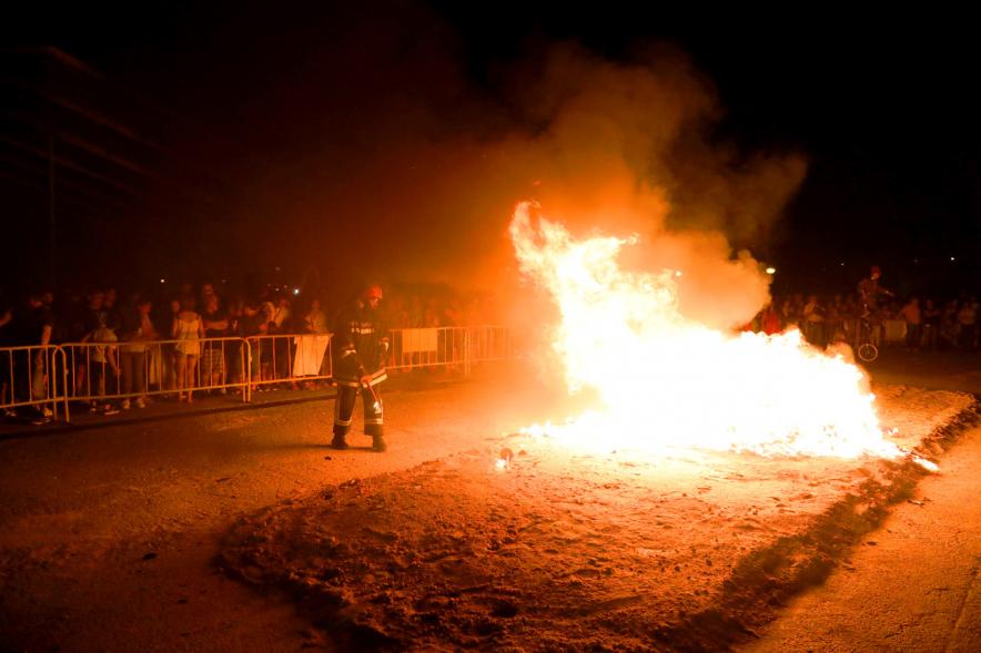 Noche de San Juan 2018 - Actividades y Hoguera de San Juan - Imagen de la llamas de la hoguera y un bombero vigilando el fuego.